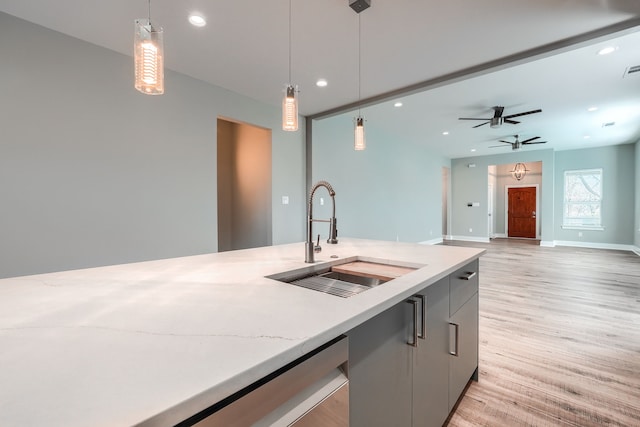 kitchen with sink, light hardwood / wood-style flooring, ceiling fan, gray cabinets, and decorative light fixtures