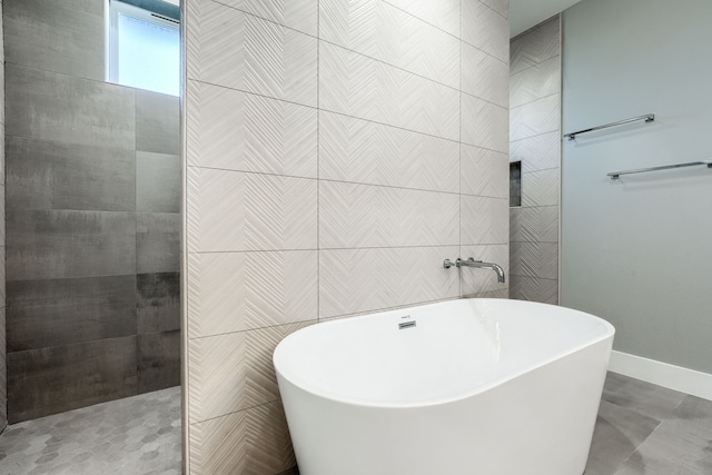 bathroom featuring tile walls and independent shower and bath