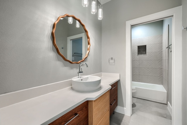 full bathroom featuring tiled shower / bath, tile patterned flooring, vanity, and toilet