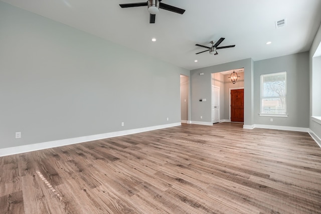 interior space featuring ceiling fan with notable chandelier and light hardwood / wood-style floors