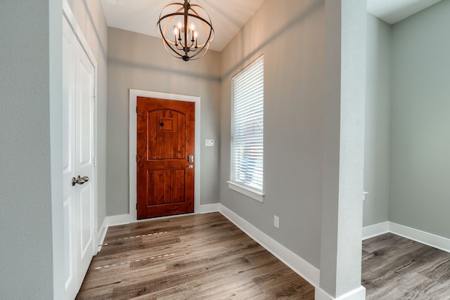 entryway featuring dark wood-type flooring and an inviting chandelier