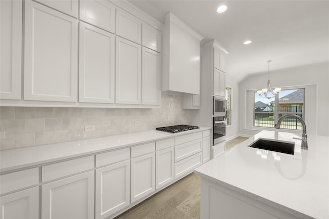 1402 Ethan Cir, Midlothian, TX 76065 - kitchen with stainless steel appliances, a sink, light wood-type flooring, light countertops, and backsplash