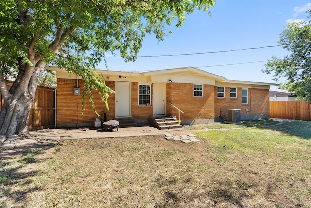 rear view of property featuring a yard and cooling unit