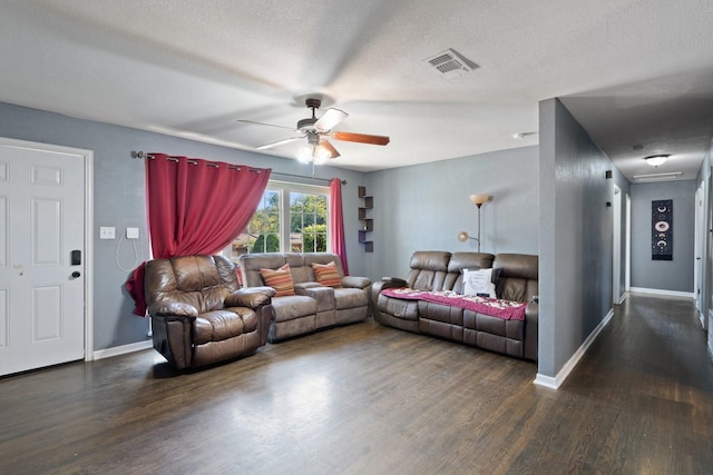 living room featuring a textured ceiling, ceiling fan, and dark wood-type flooring