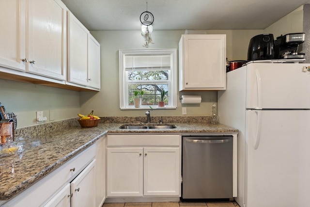 kitchen featuring dishwasher, white fridge, light stone counters, and white cabinetry