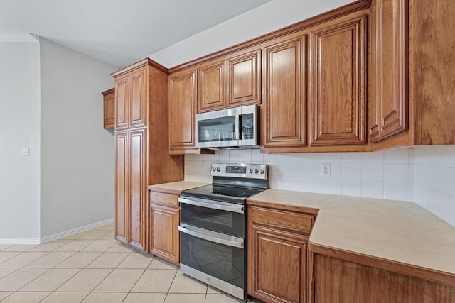 kitchen featuring light tile patterned floors, appliances with stainless steel finishes, and decorative backsplash