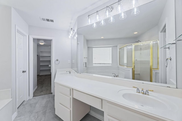 bathroom with vanity and shower with separate bathtub