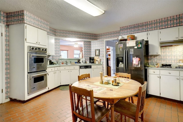 kitchen with ceiling fan, white cabinetry, stainless steel appliances, a textured ceiling, and decorative backsplash