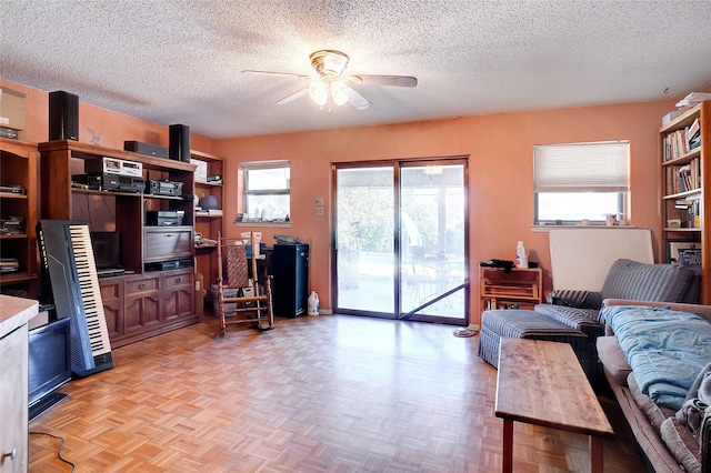 living room with a textured ceiling, a wealth of natural light, and light parquet flooring