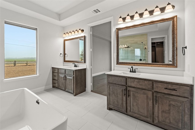 bathroom with vanity, shower with separate bathtub, tile patterned floors, and a tray ceiling