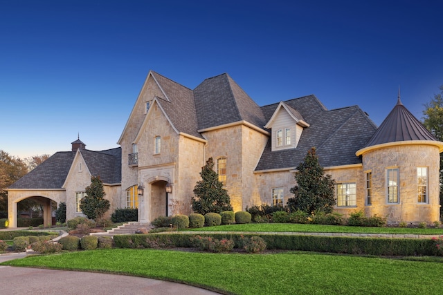 french country inspired facade with a front yard