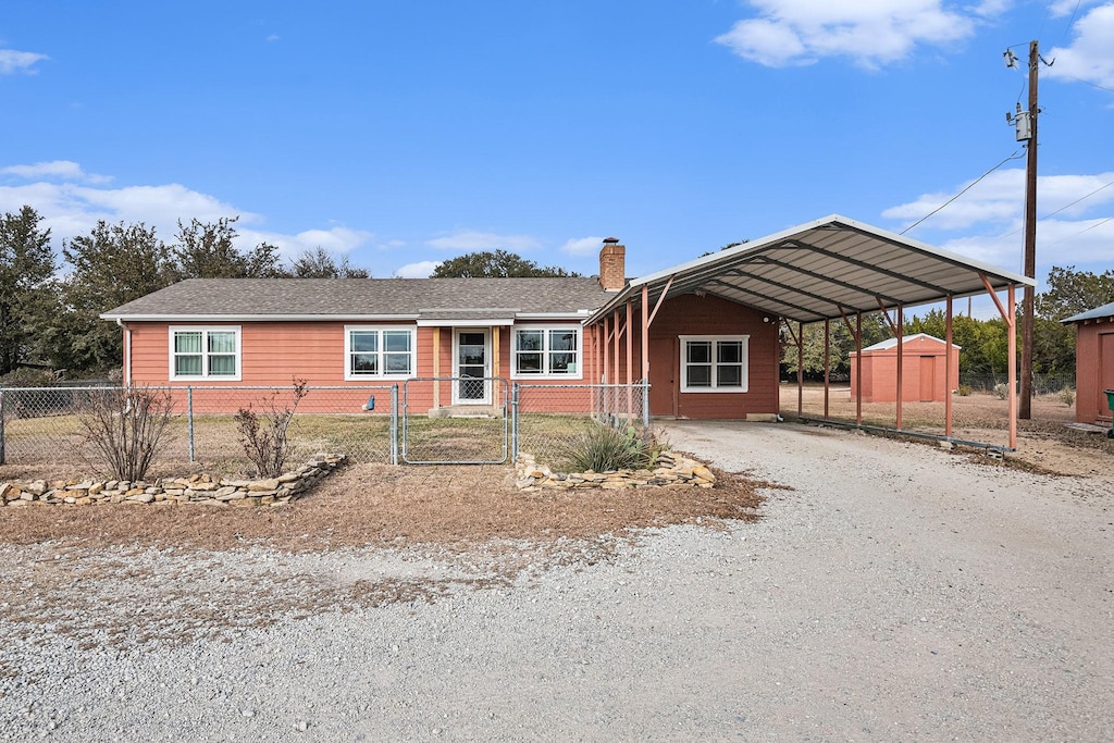 view of front of home featuring a storage unit and a carport