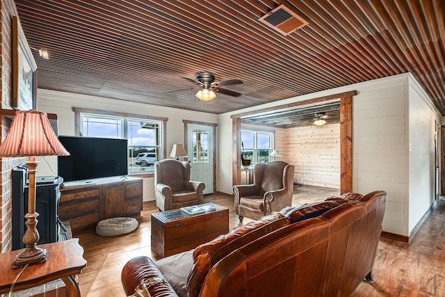 living room featuring wood ceiling, wooden walls, and light hardwood / wood-style flooring