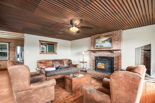 living room with ceiling fan, wood ceiling, wooden walls, and light hardwood / wood-style floors