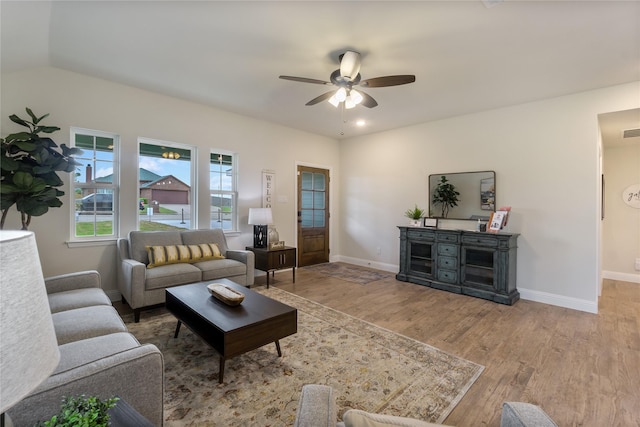 living room with hardwood / wood-style floors, ceiling fan, and vaulted ceiling