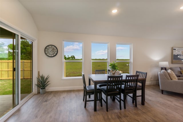 dining area with a healthy amount of sunlight, lofted ceiling, and light wood-type flooring