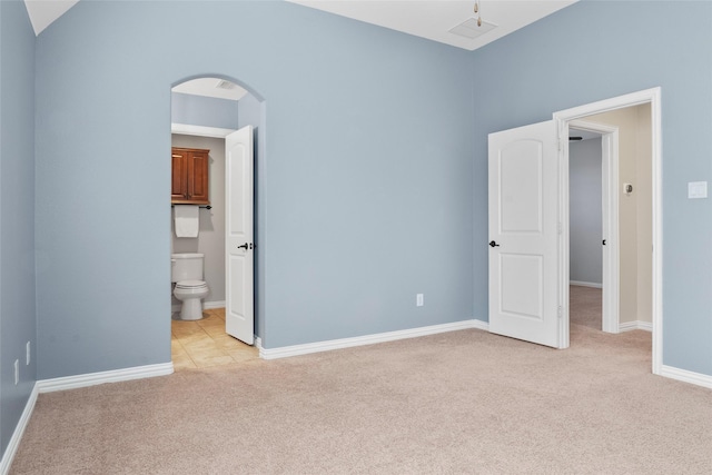 unfurnished bedroom with light carpet and ensuite bathroom