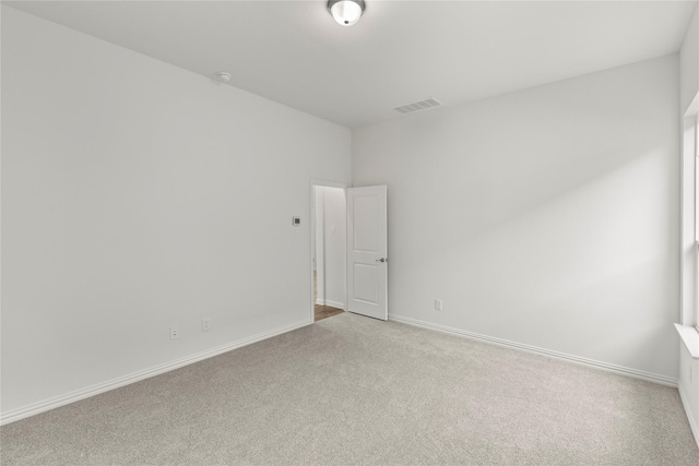 unfurnished room featuring light carpet