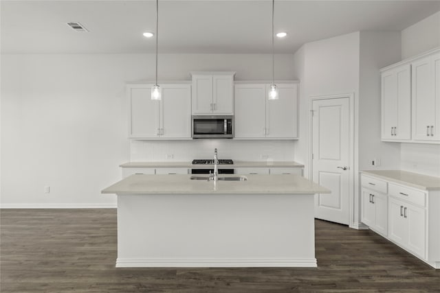 kitchen featuring sink, dark hardwood / wood-style floors, pendant lighting, a kitchen island with sink, and white cabinets