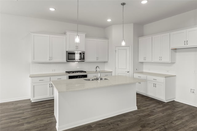 kitchen with white cabinets, sink, and an island with sink