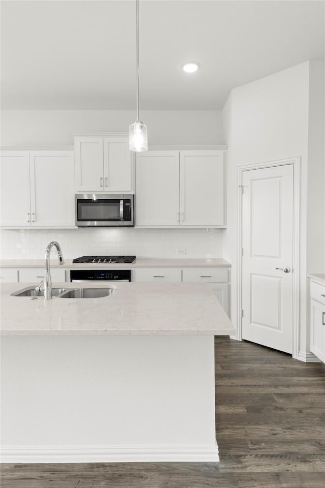 kitchen featuring light stone countertops, dark wood-type flooring, sink, decorative light fixtures, and white cabinets