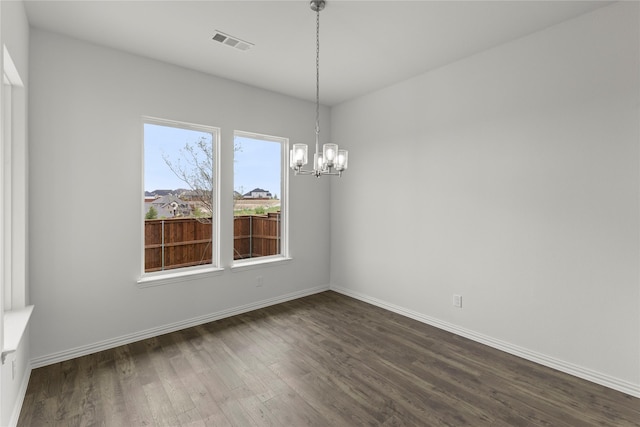 unfurnished dining area with dark hardwood / wood-style flooring and an inviting chandelier