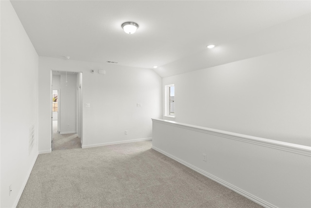 unfurnished room featuring light colored carpet and lofted ceiling