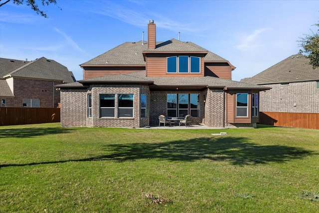 back of house featuring a patio area and a lawn