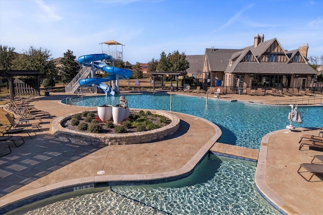 view of swimming pool with a water slide and a playground