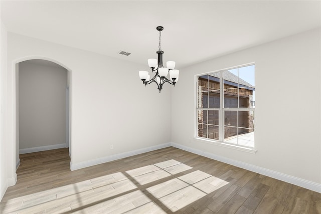 unfurnished dining area with light hardwood / wood-style flooring and a notable chandelier