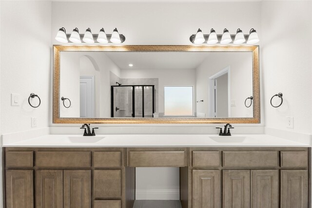 bathroom with vanity and a shower with door