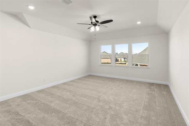 empty room featuring light carpet, vaulted ceiling, and ceiling fan