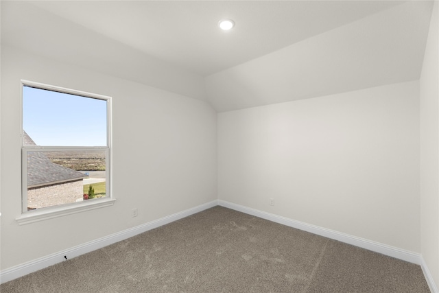 additional living space featuring carpet floors and vaulted ceiling