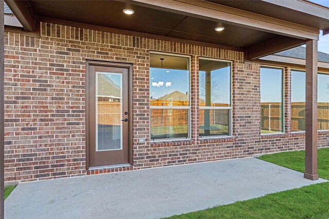 view of exterior entry with a patio