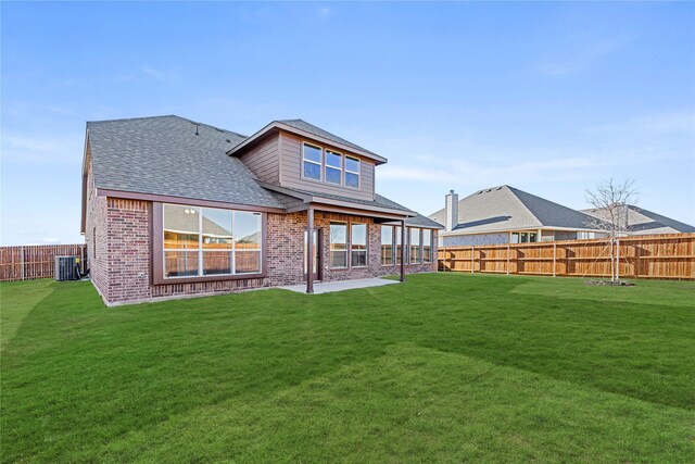 rear view of property featuring a lawn and a patio area