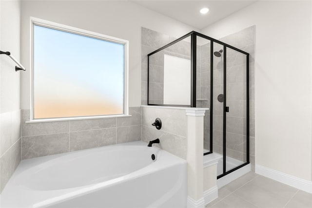 bathroom with separate shower and tub, a healthy amount of sunlight, and tile patterned floors