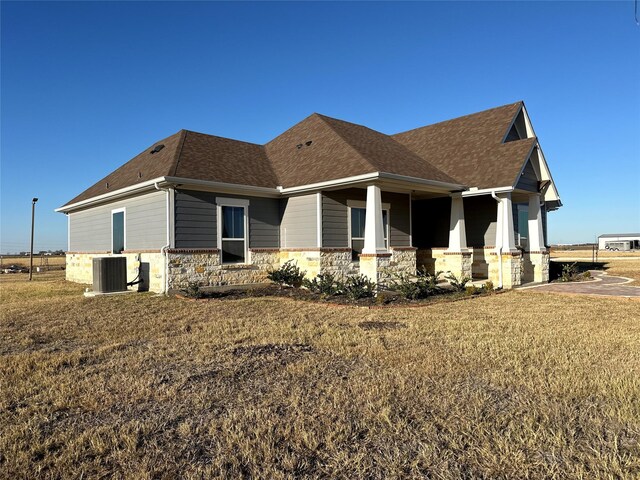 view of side of property featuring a yard and central AC unit