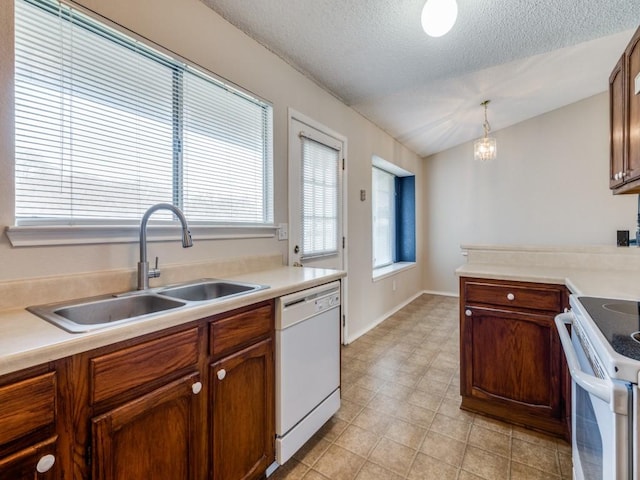 kitchen with white appliances, light countertops, lofted ceiling, and a sink