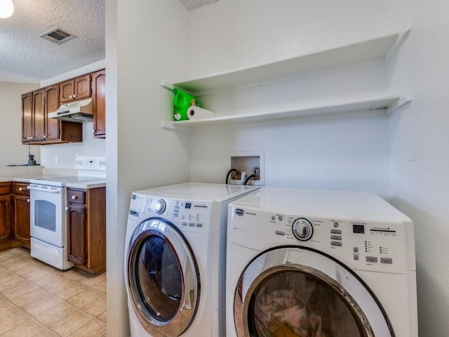 clothes washing area with laundry area, a textured ceiling, visible vents, and separate washer and dryer