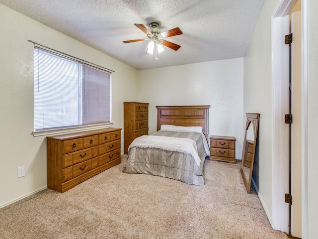 bedroom with carpet flooring, a textured ceiling, and a ceiling fan