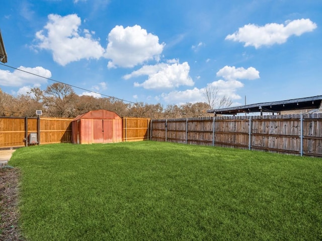 view of yard featuring an outdoor structure, a fenced backyard, and a shed