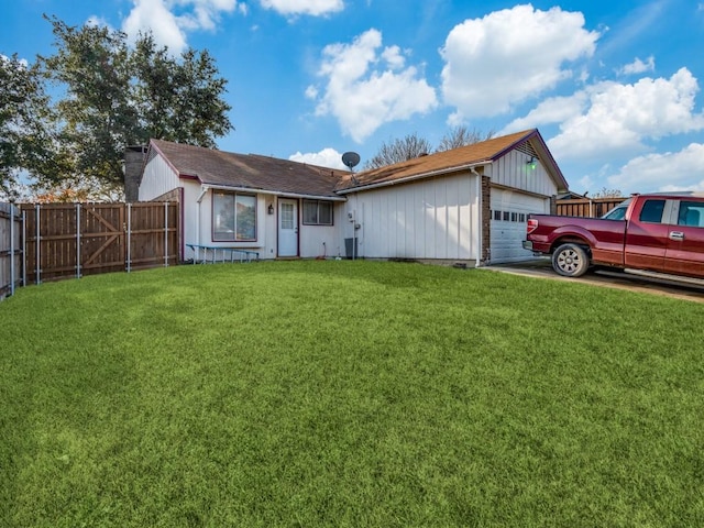 ranch-style home featuring a front yard, fence, and a garage