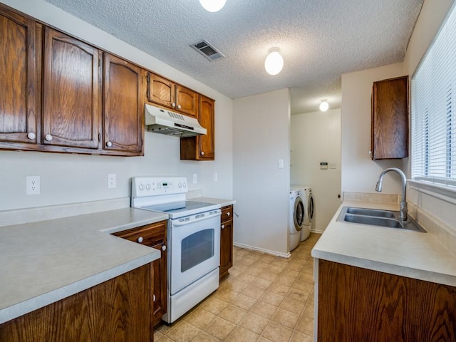 kitchen with visible vents, under cabinet range hood, a sink, white electric range oven, and washing machine and clothes dryer