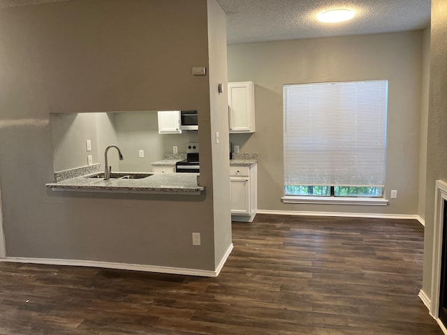 kitchen with sink, white cabinetry, a textured ceiling, appliances with stainless steel finishes, and light stone countertops