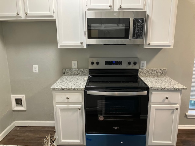 kitchen with white cabinets, light stone counters, and appliances with stainless steel finishes