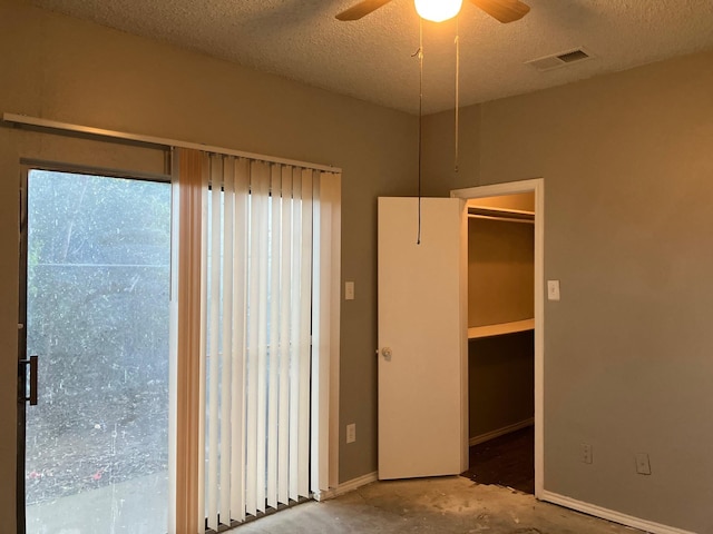 empty room featuring ceiling fan, a textured ceiling, and concrete floors