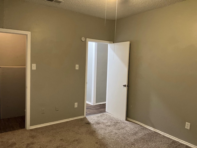 unfurnished bedroom with a textured ceiling and carpet floors