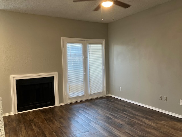 unfurnished living room with ceiling fan, dark wood-type flooring, and a textured ceiling