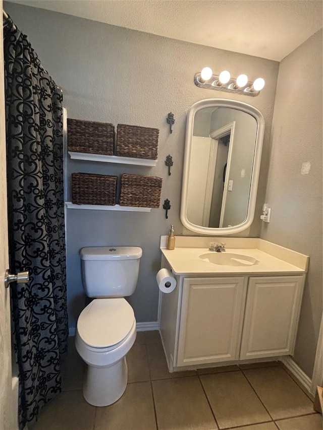 bathroom with tile patterned flooring, vanity, and toilet