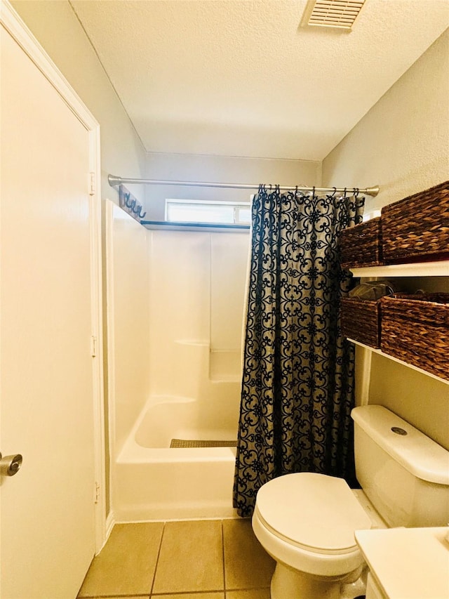 full bathroom with vanity, a textured ceiling, shower / bath combo with shower curtain, tile patterned flooring, and toilet